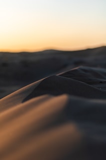 Sunset casting warm, golden hues over Merzouga’s towering sand dunes