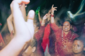 A festive celebration with students and teachers sharing laughter and traditional music.