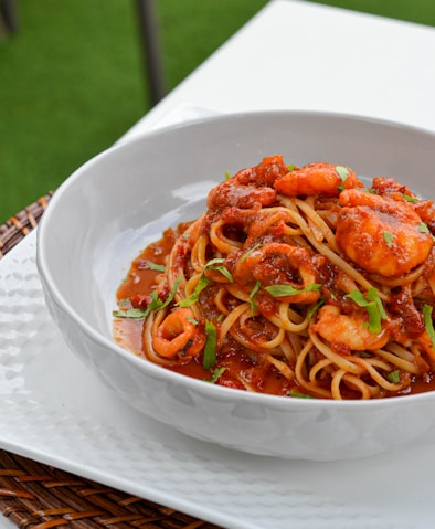 a bowl of pasta with shrimp and tomato sauce