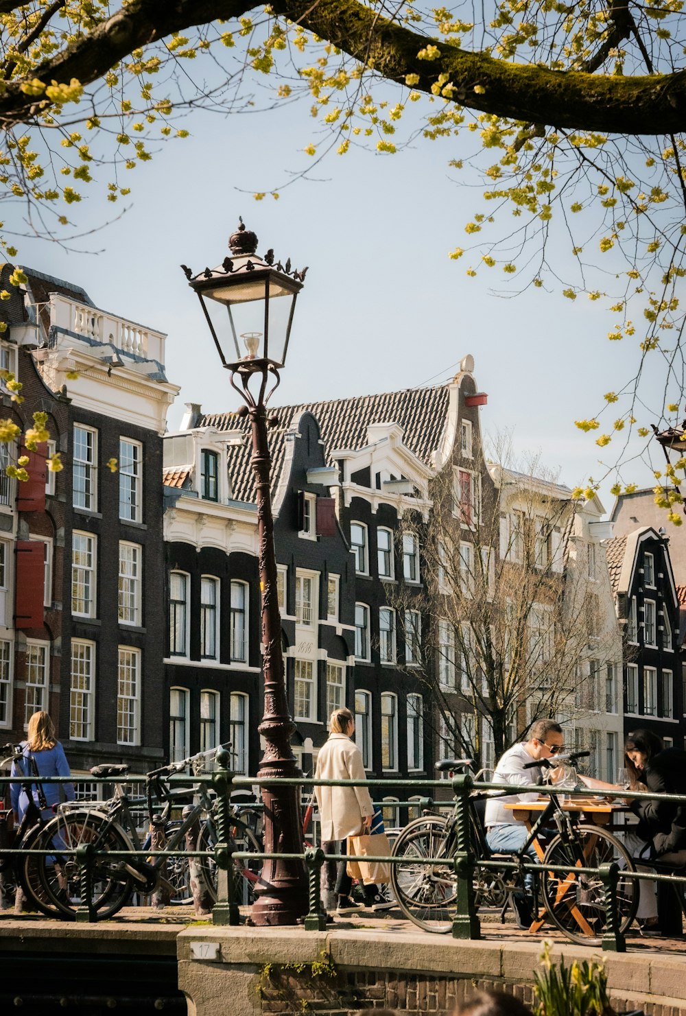 a group of people sitting on a bench next to a lamp post