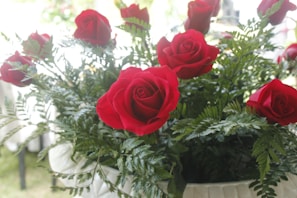Close-up of vibrant artificial red roses arranged in a decorative vase