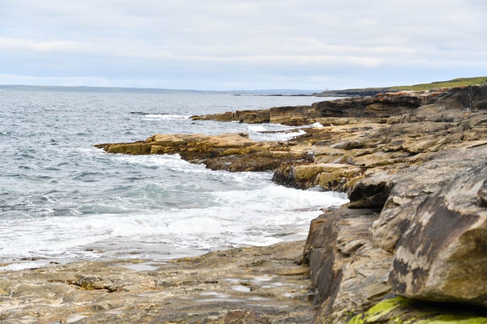 a rocky shore line with a body of water