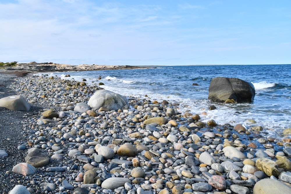 a rocky beach next to a body of water