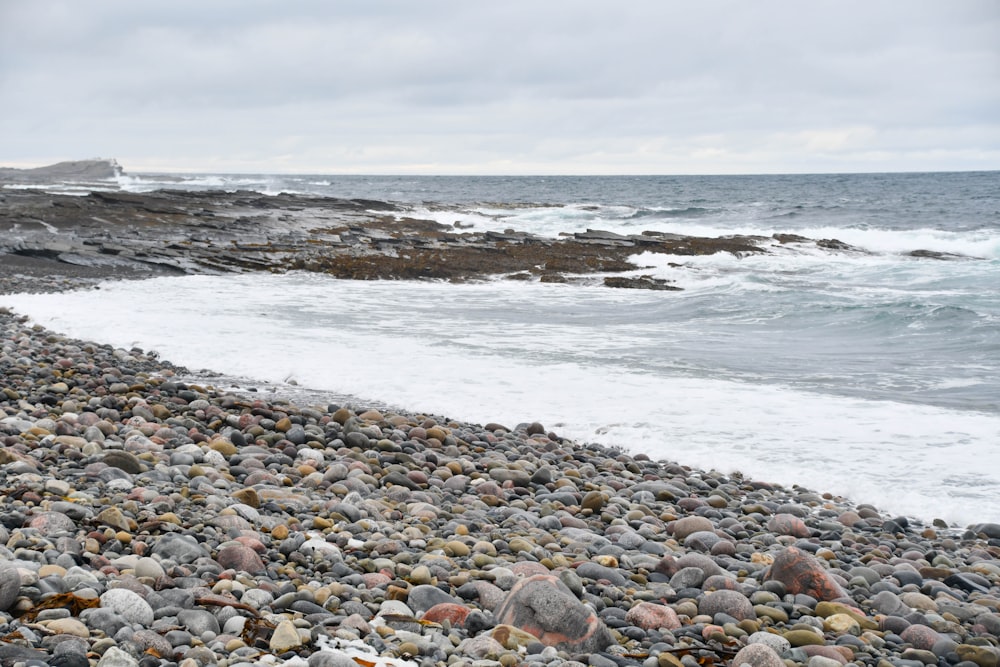 a bunch of rocks on a beach near the ocean