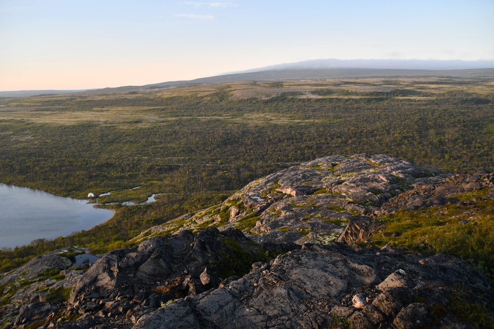 a large body of water sitting on top of a lush green hillside