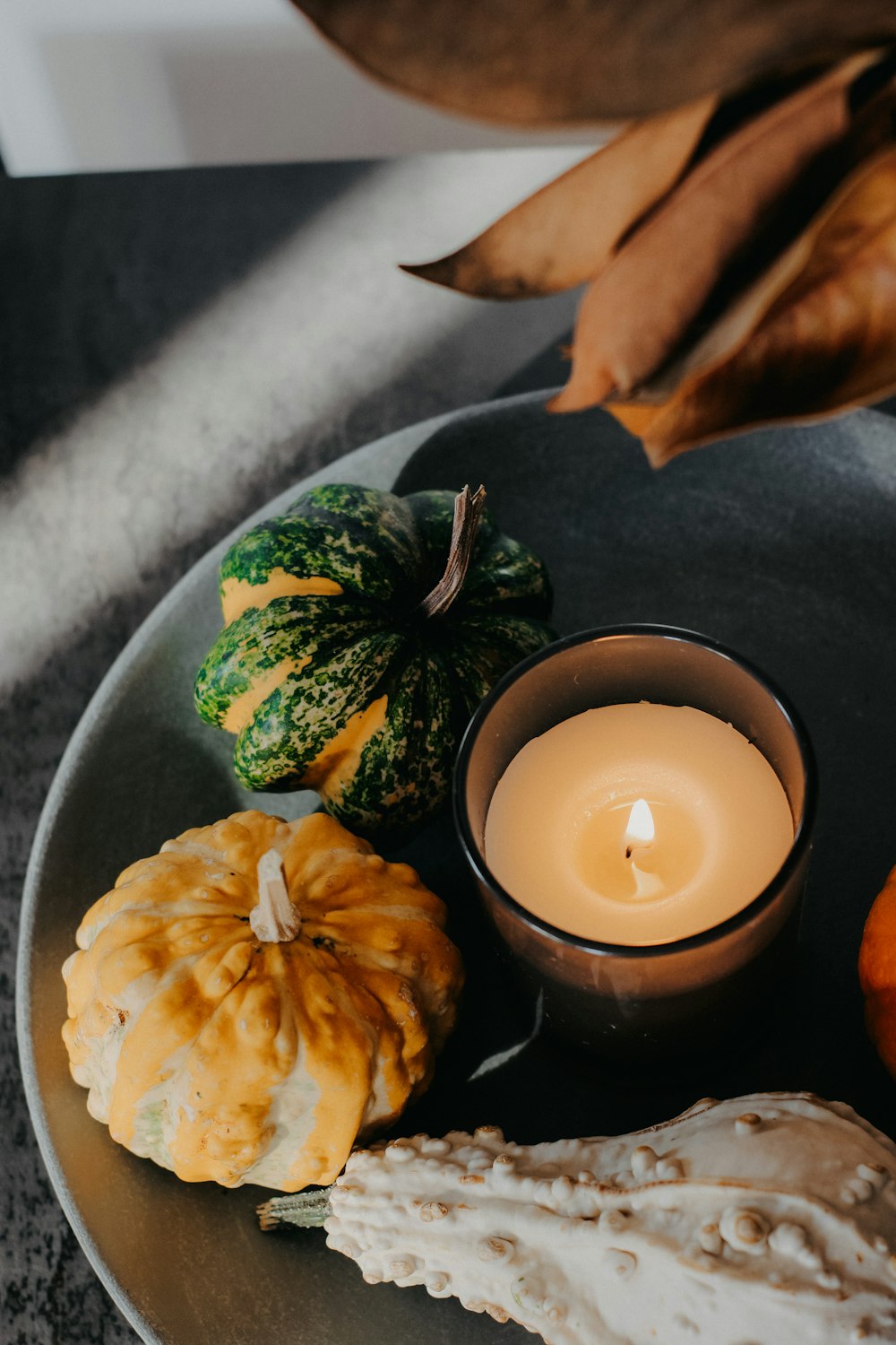 a plate of food with a candle and some pumpkins