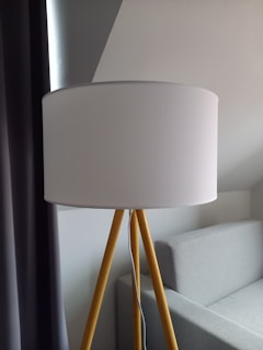 A giant lamp standing tall beside a modern sofa in a stylish loft.