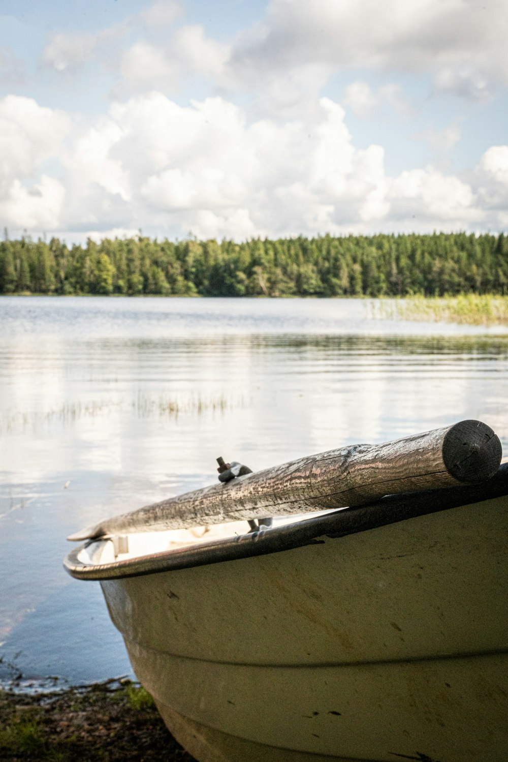 a boat sitting on the shore of a lake