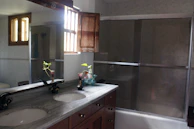 Bathroom vanity area with modern sink and large mirror reflecting natural light.