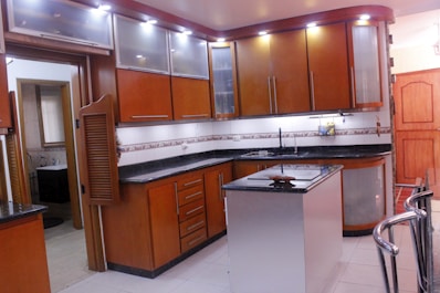 a kitchen with wooden cabinets and black counter tops
