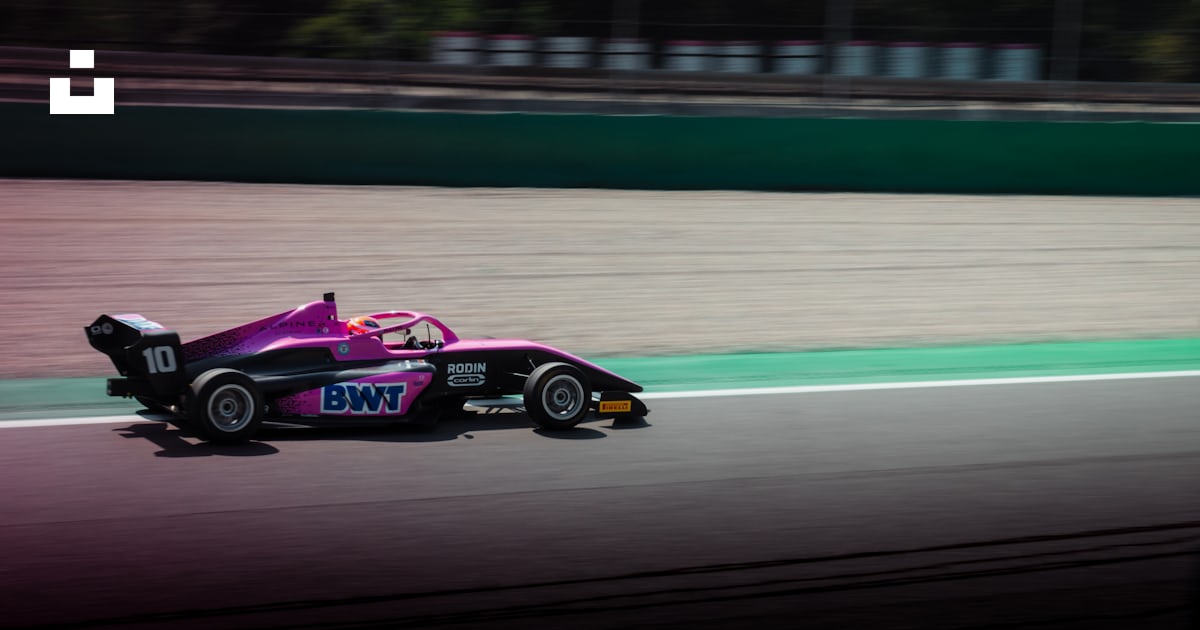 A pink race car driving down a race track photo – Free Wallpaper Image ...