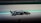 A black and white racing car speeds along a track, capturing the essence of motion and speed.