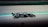 A black and white racing car speeds along a track, capturing the essence of motion and speed.
