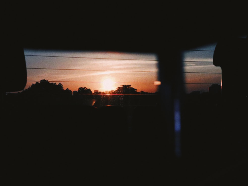 the sun is setting in the distance as seen from a vehicle
