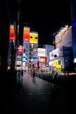 a group of people walking down a street next to tall buildings