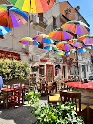 a group of colorful umbrellas hanging from the side of a building