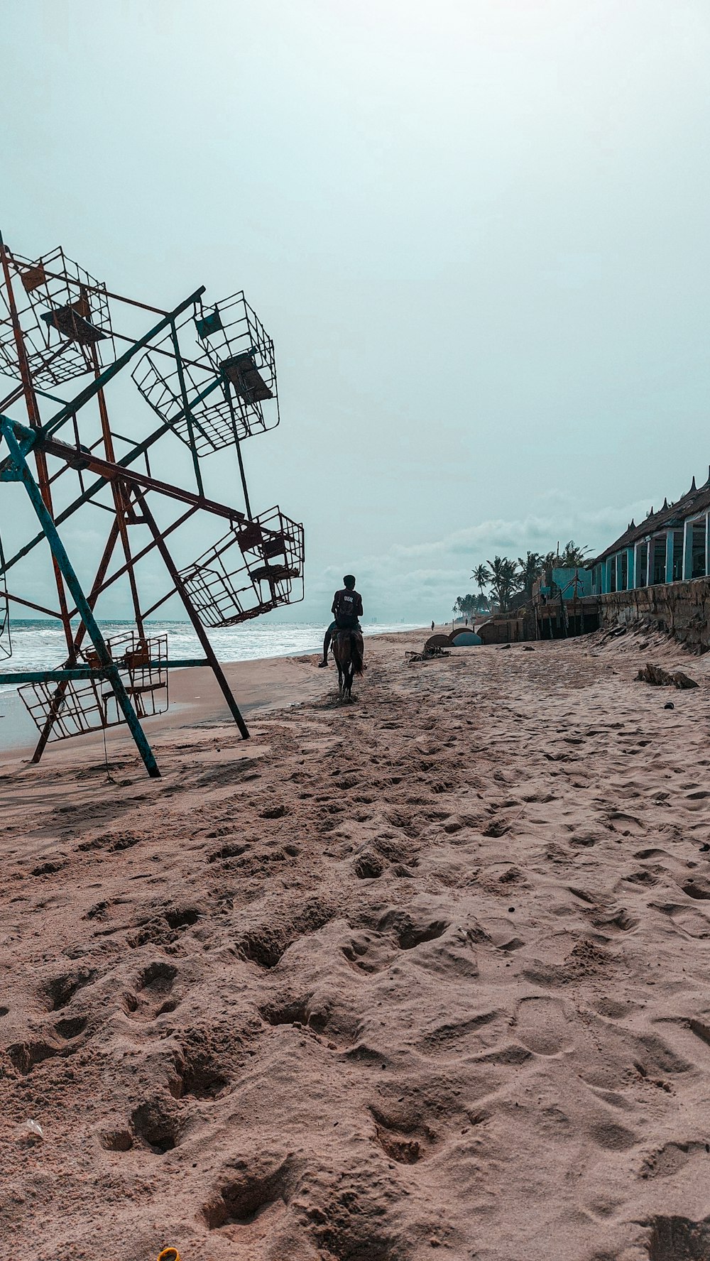 a man walking on a beach next to a life guard tower