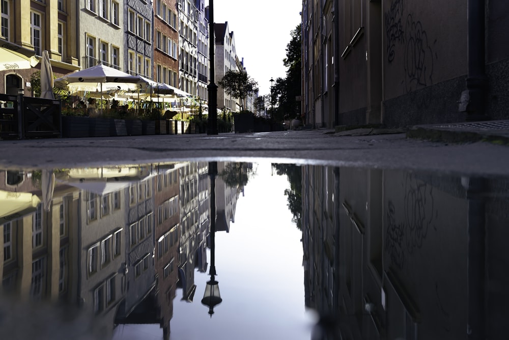 a reflection of buildings in a puddle of water