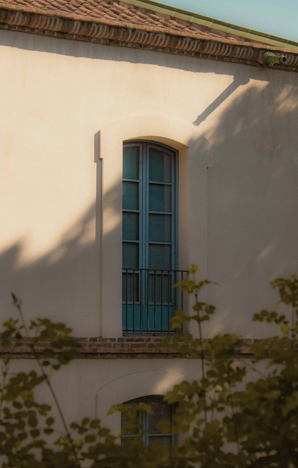 a white building with a blue window and green shutters