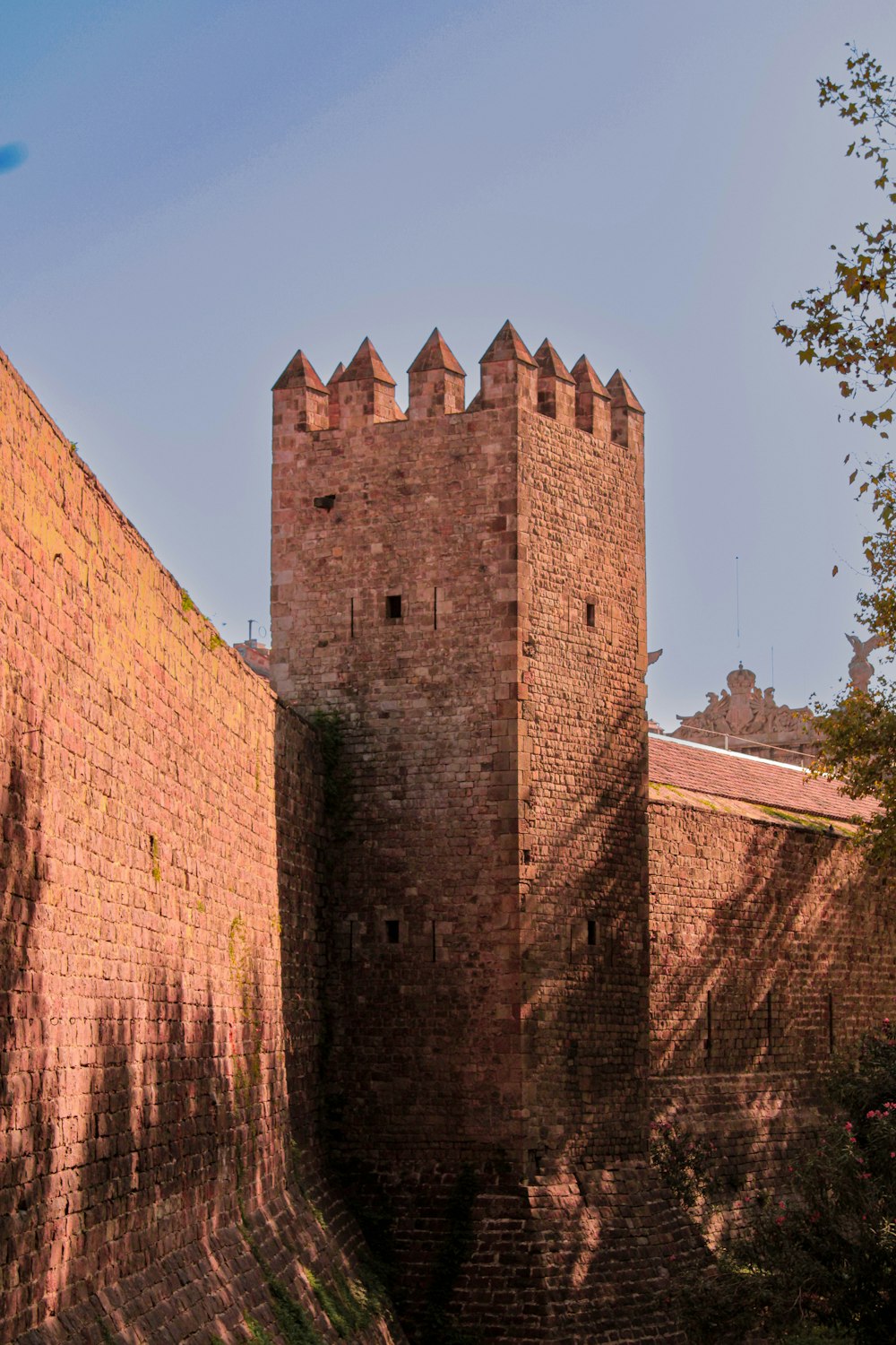 a tall brick tower sitting next to a lush green forest