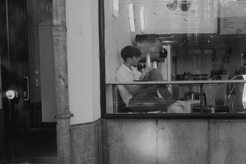 a man sitting at a counter in front of a store