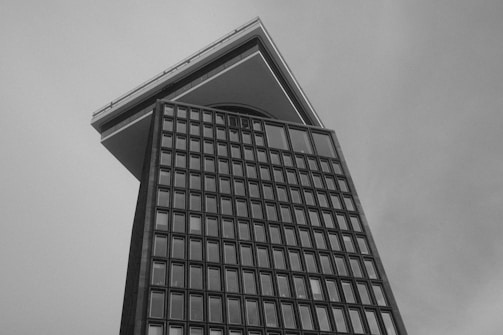 Grid-based architectural blueprint overlay on a black and white building photo.