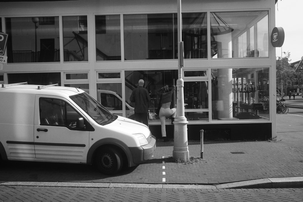 a white van parked in front of a building