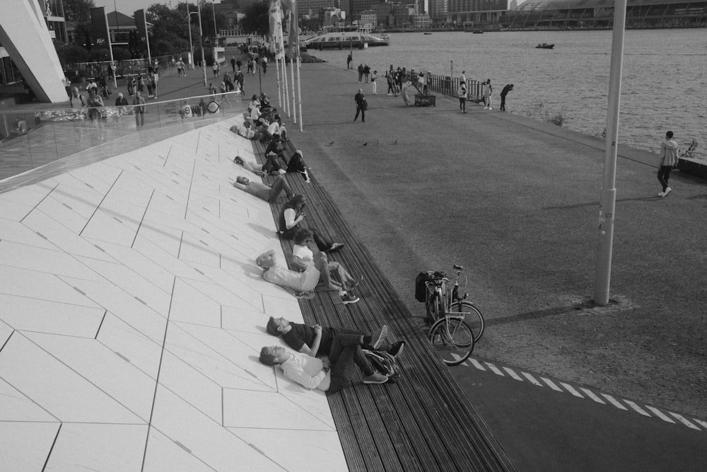 a group of people laying on the ground next to a body of water