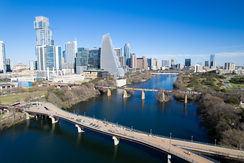 a bridge over a river with a city in the background