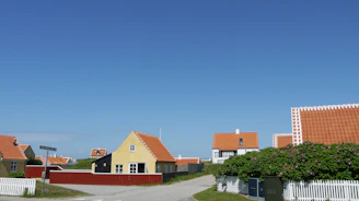 A charming village with cobblestone streets and colorful houses under a bright sky.