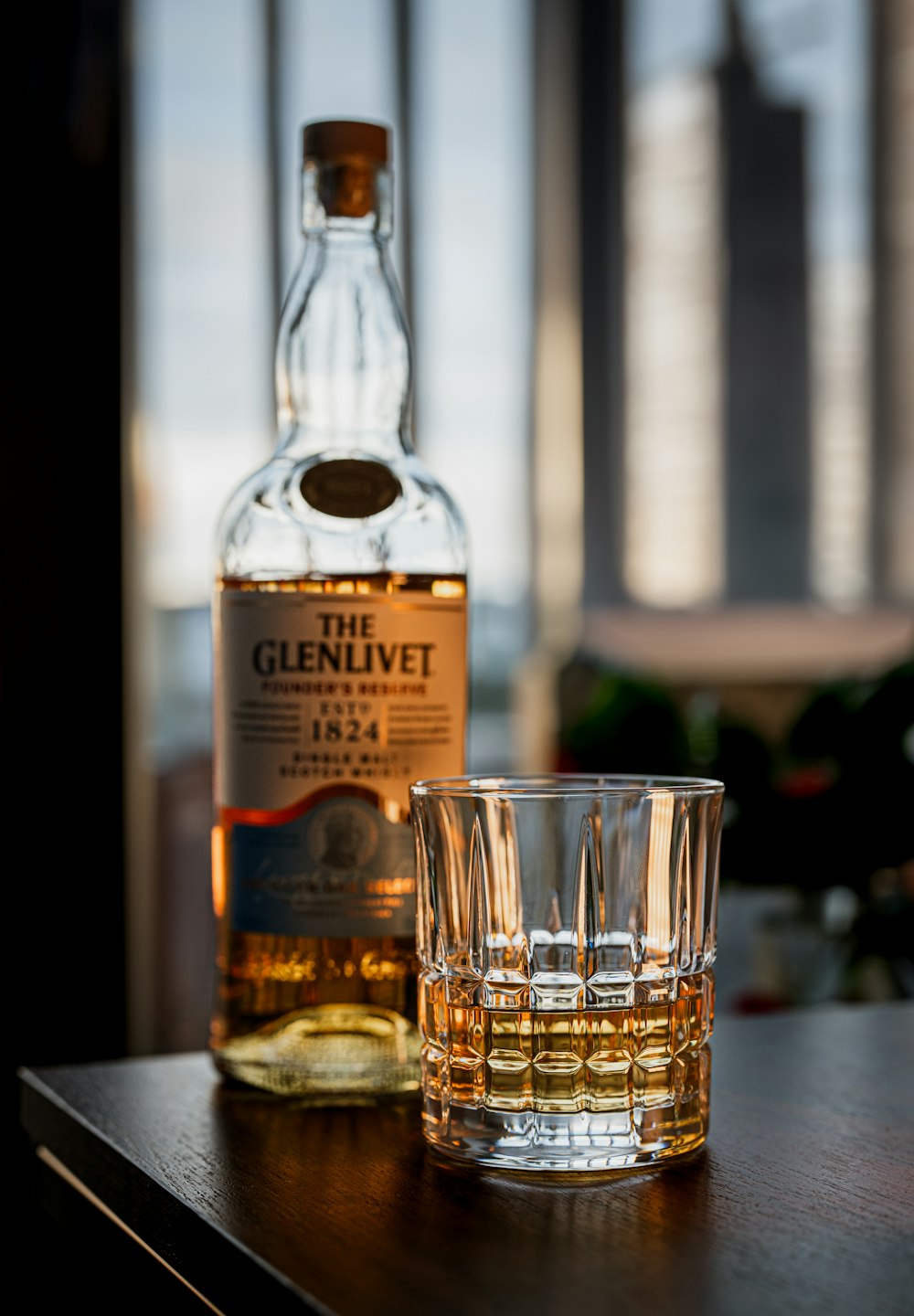 a bottle of whisky next to a glass on a table