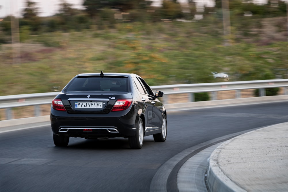 a black car driving down a curvy road