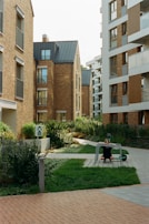 A landscaped courtyard with benches and greenery between apartment buildings.