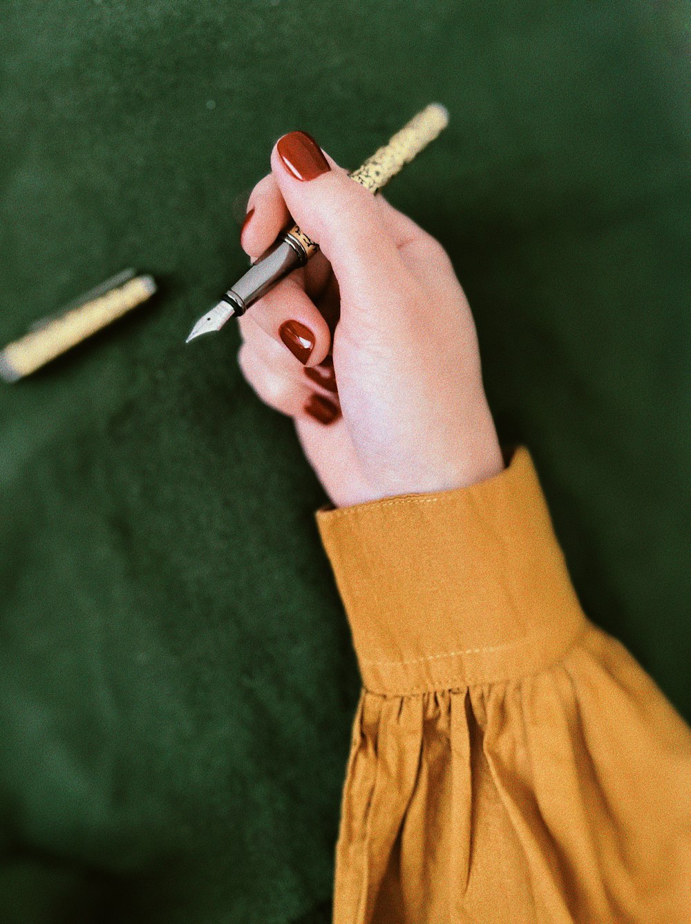 a person holding a pen and writing on a piece of paper