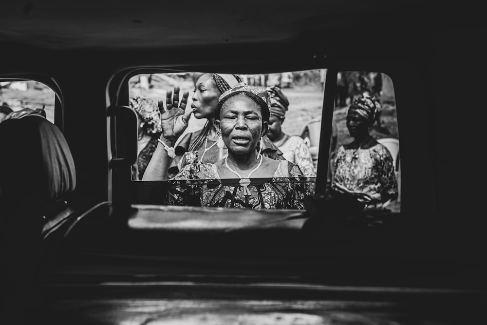 a black and white photo of a woman on a bus