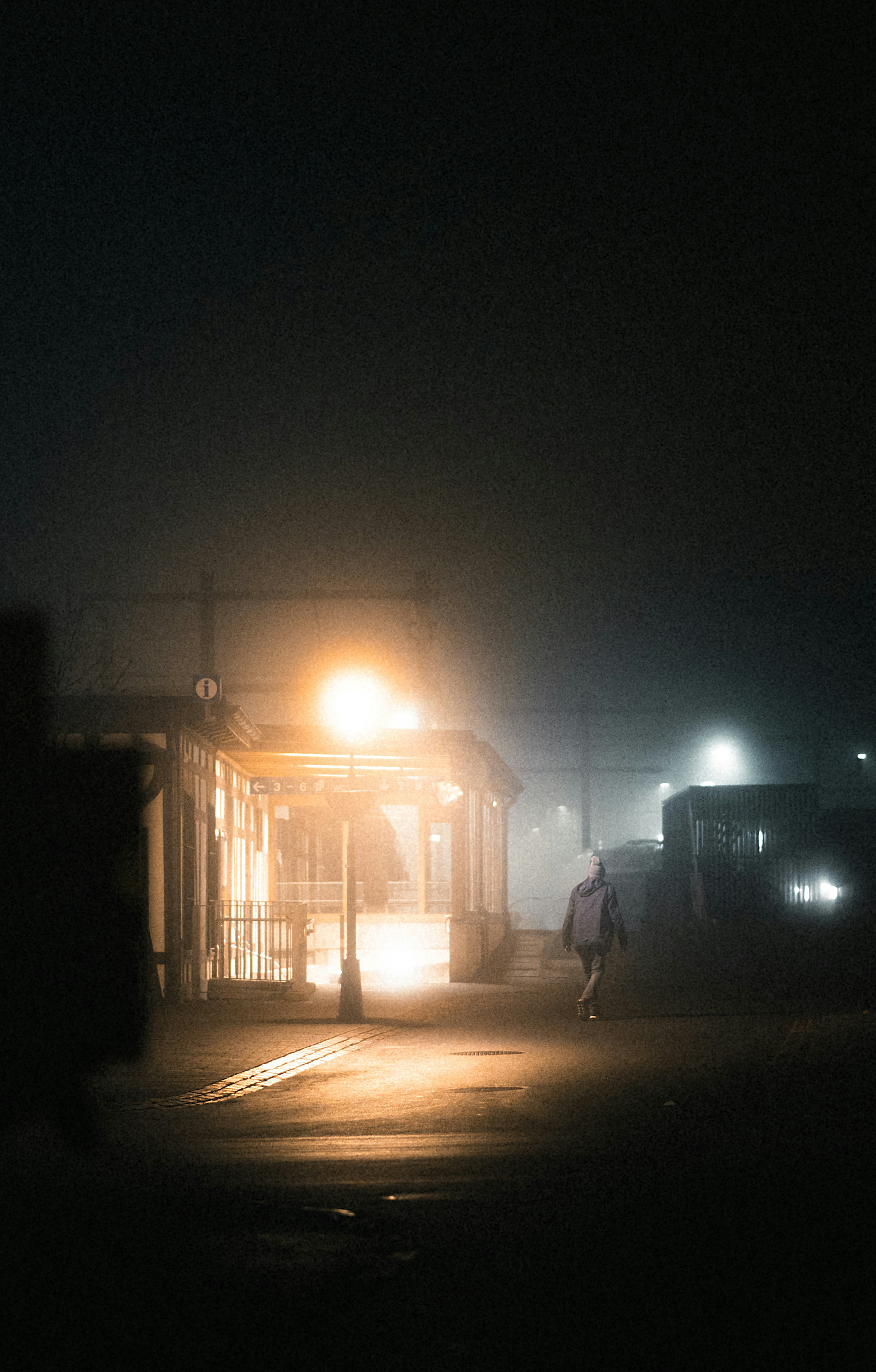 uma pessoa andando por uma rua à noite