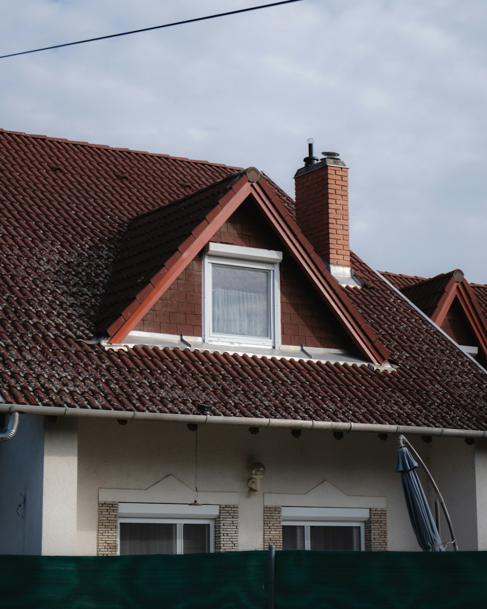 a house with a brown roof and a white window