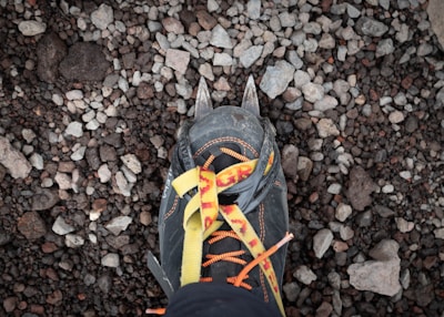A close-up of climbing shoes on a rocky surface.