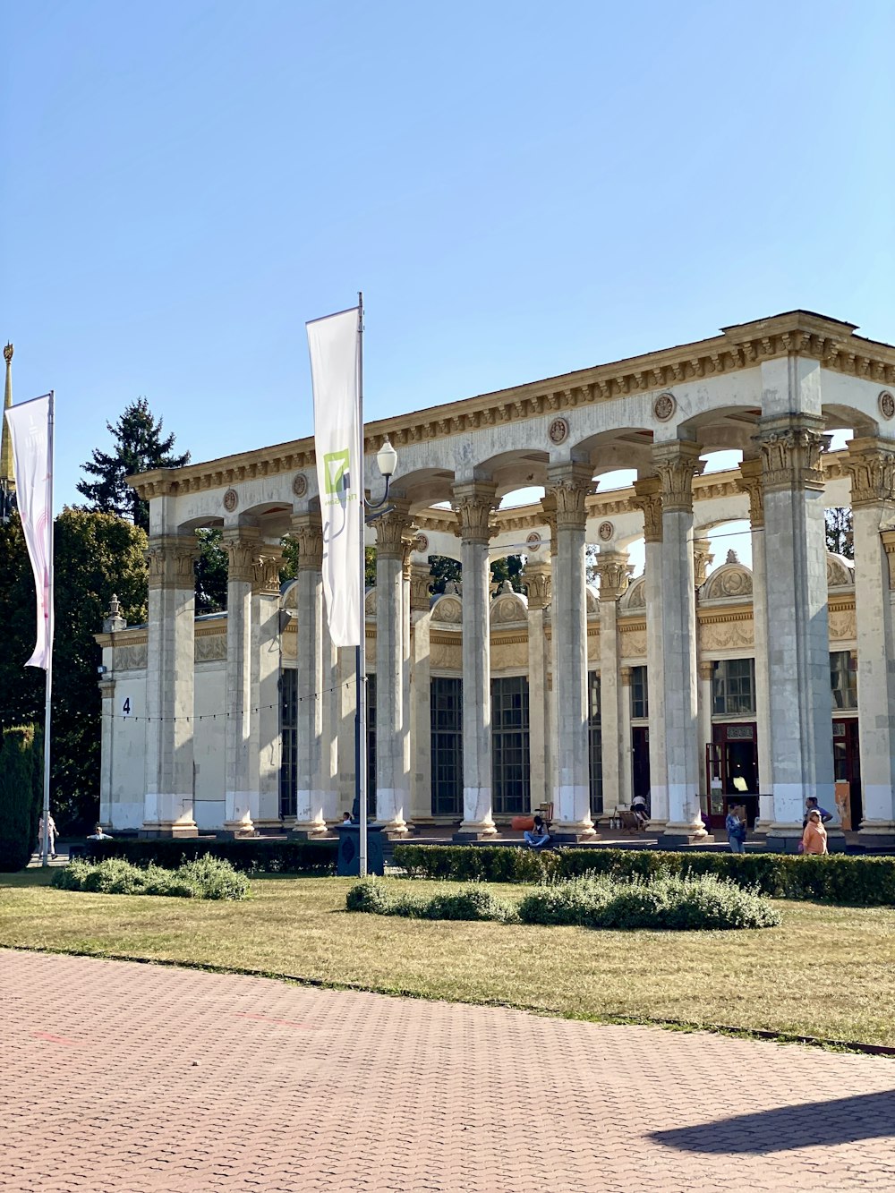 a white building with columns and flags in front of it