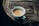 A steaming cup of coffee on a rustic wooden table.