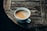 A steaming cup of freshly brewed coffee on a rustic wooden table.