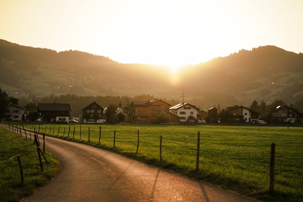 the sun is setting over a green field