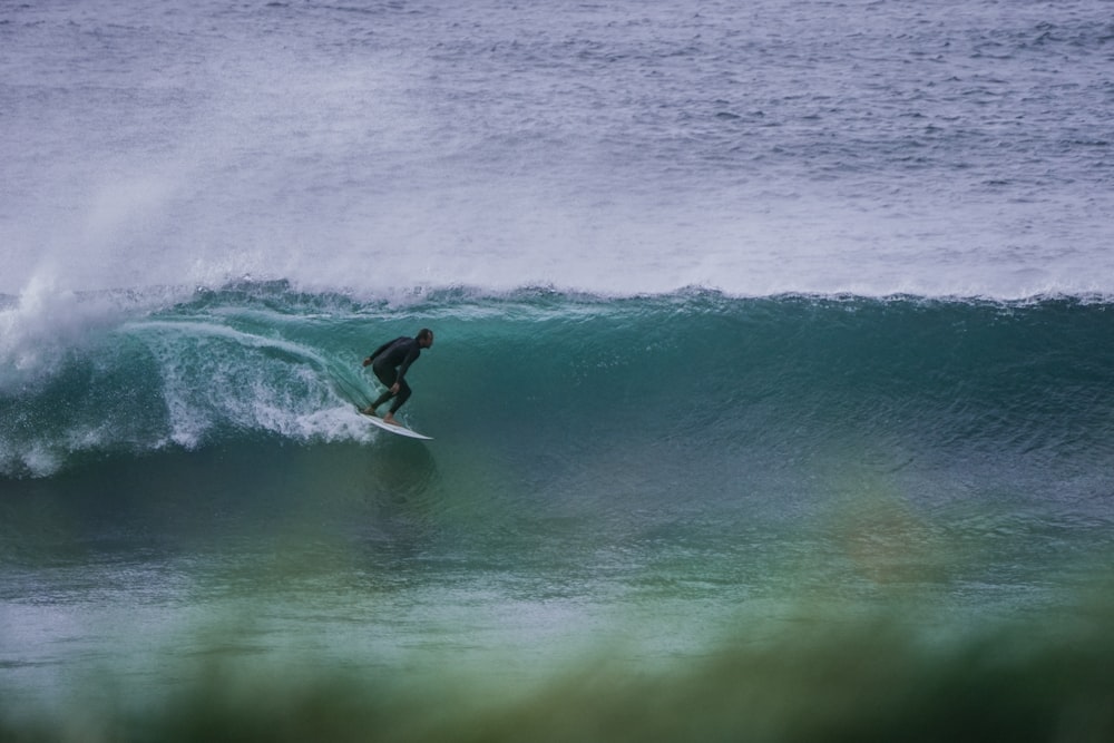 a man riding a wave on top of a surfboard