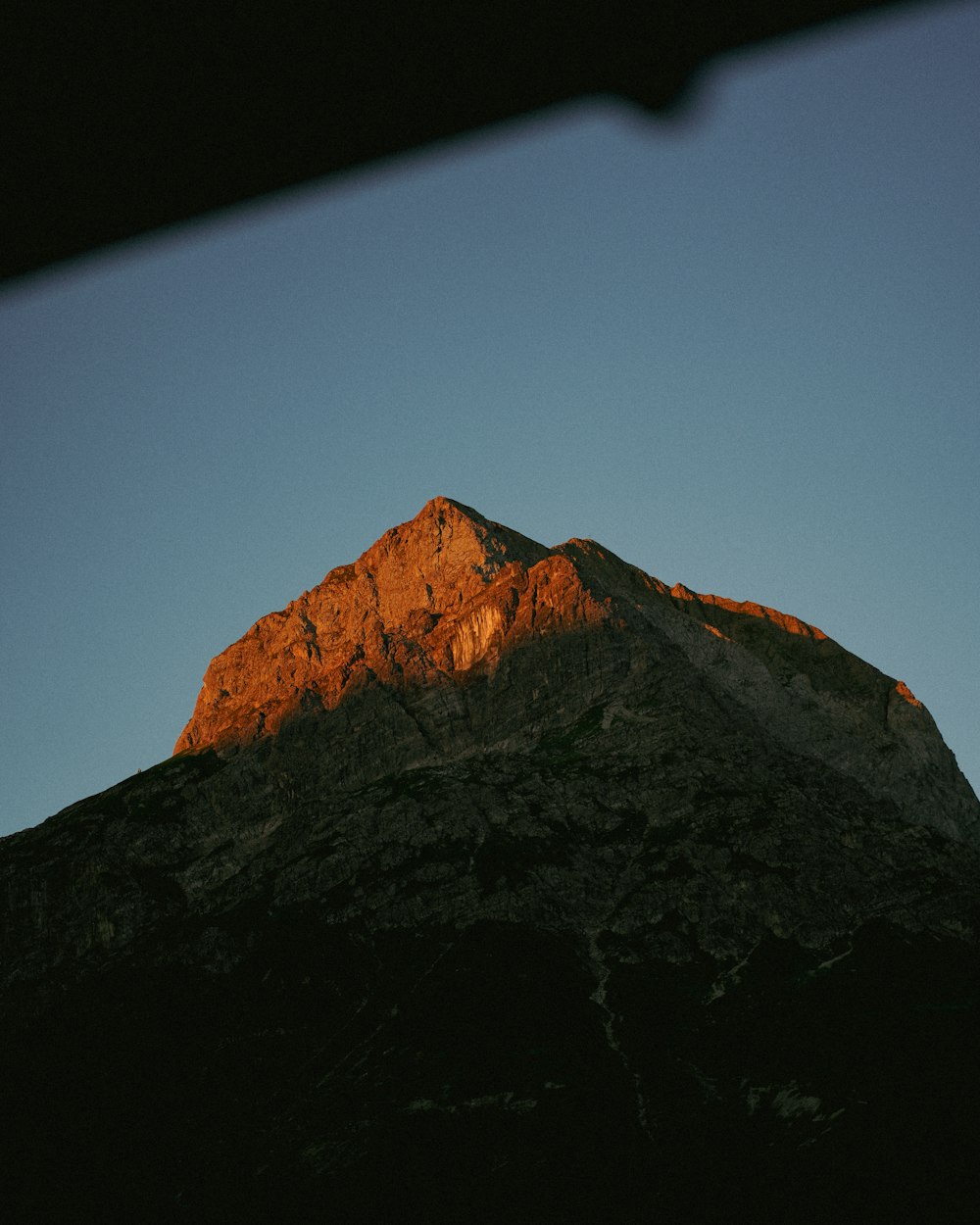 the top of a mountain with a clear sky in the background