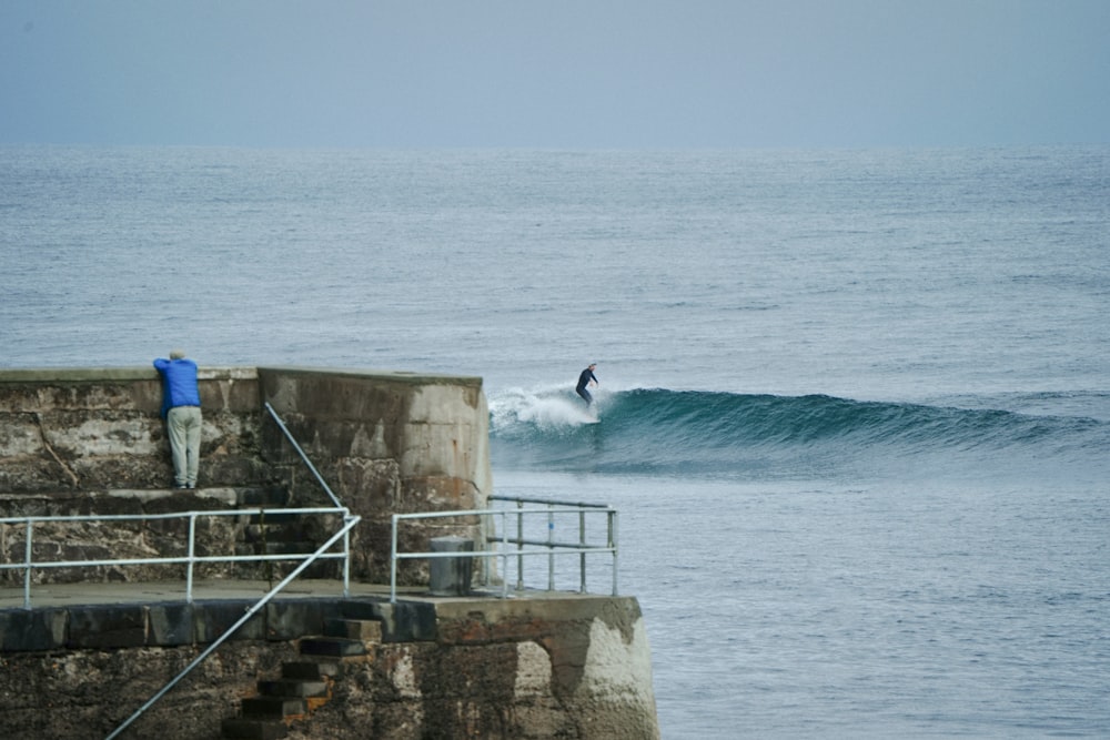 a man riding a wave on top of a surfboard