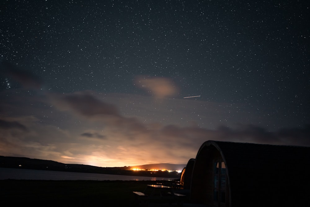 the night sky with stars above a body of water