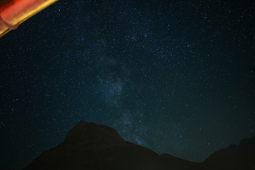 a view of the night sky with a mountain in the background