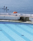 A calm poolside scene with instructors preparing for the next private lesson.