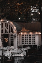 A cozy boutique hotel terrace decorated with warm lights and elegant outdoor seating.