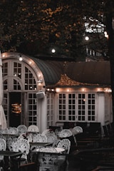 A cozy outdoor café scene with stacked chairs featuring sleek, heated cushions glowing softly in the evening light.